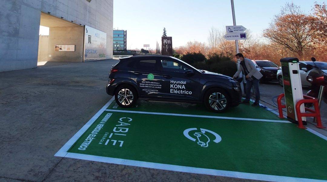 Hombre cargando un coche eléctrico a las puertas del Centro Cultural CajaGranada