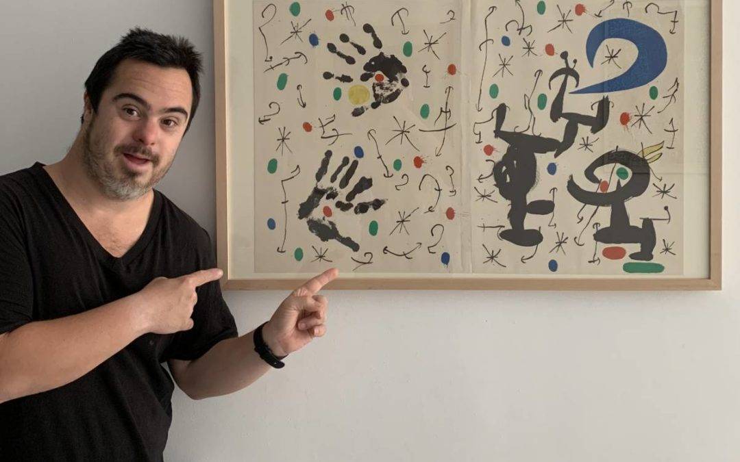 Manuel López mostrando una obra de arte
