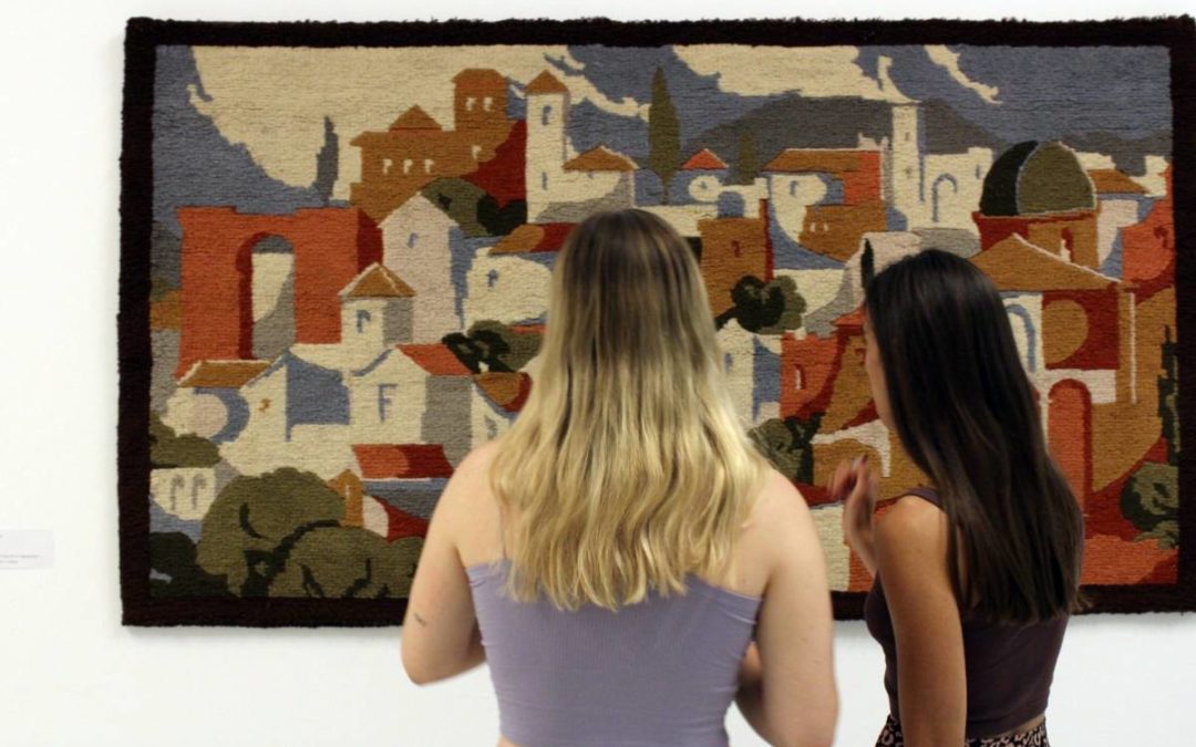 Dos personas observando una de las piezas de la exposición 'Tejidos'